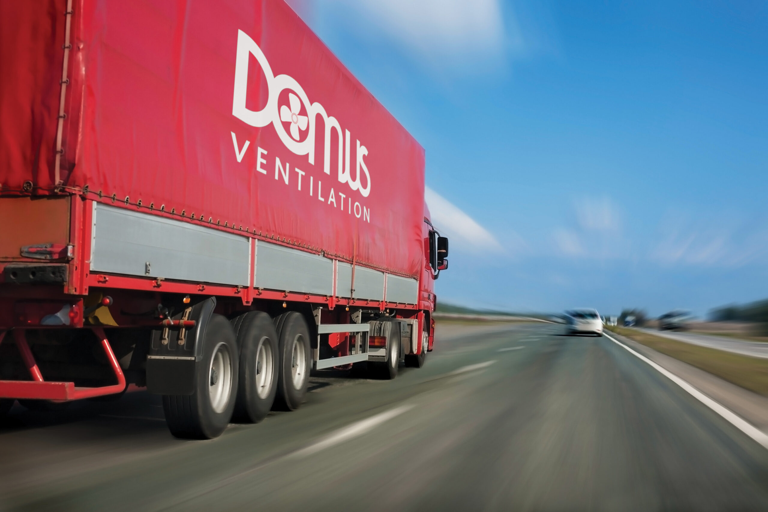 Domus lorry with red awning moves at high speed on the highway